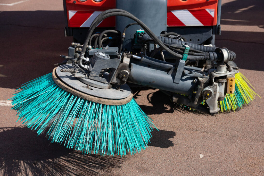 Hellblaue Bürsten einer Straßenkehrmaschine